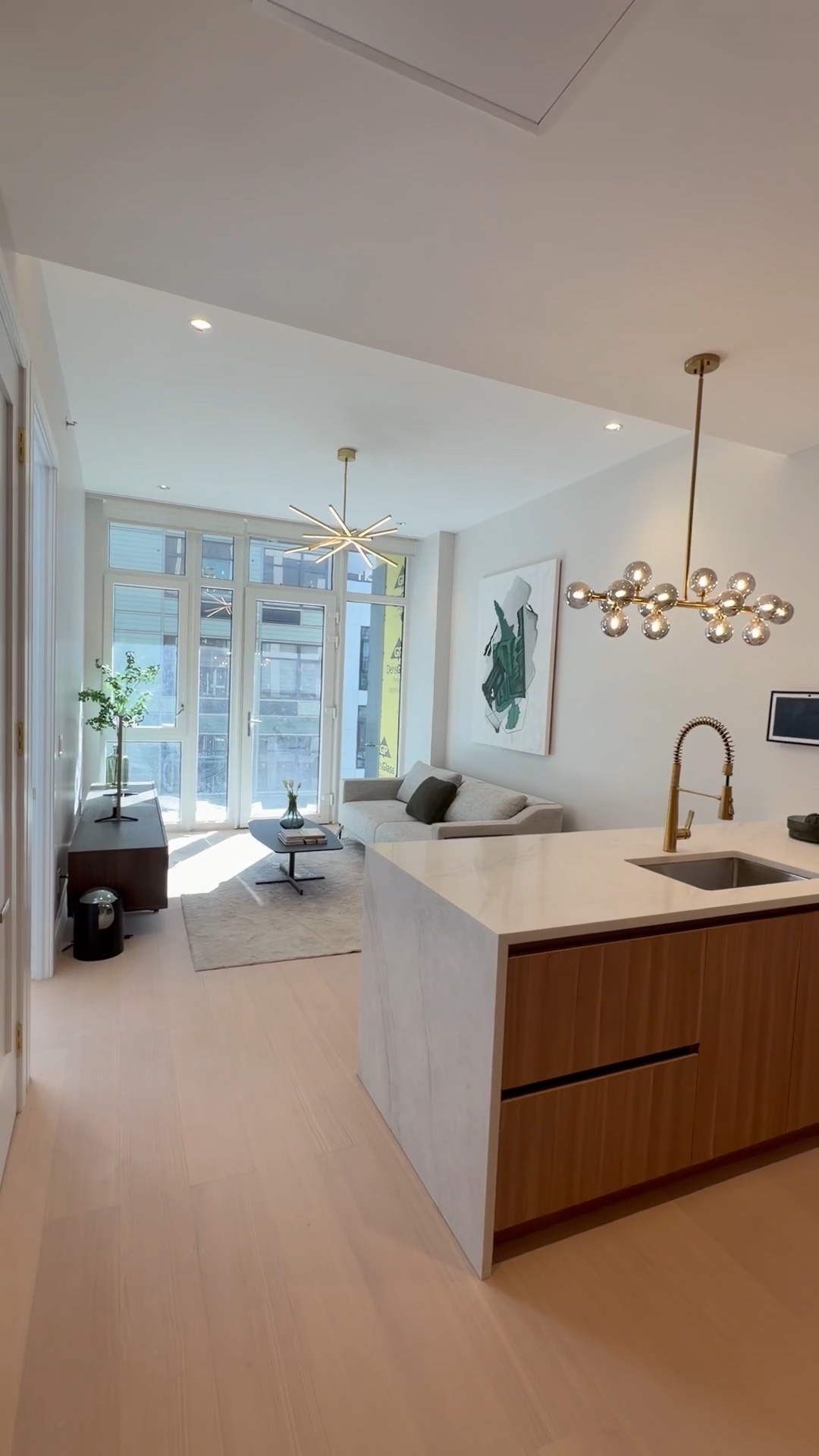 Stone kitchen island with oak cabinetry and a brass tap